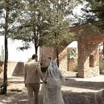 Novios caminando hacia arquitectura de piedra